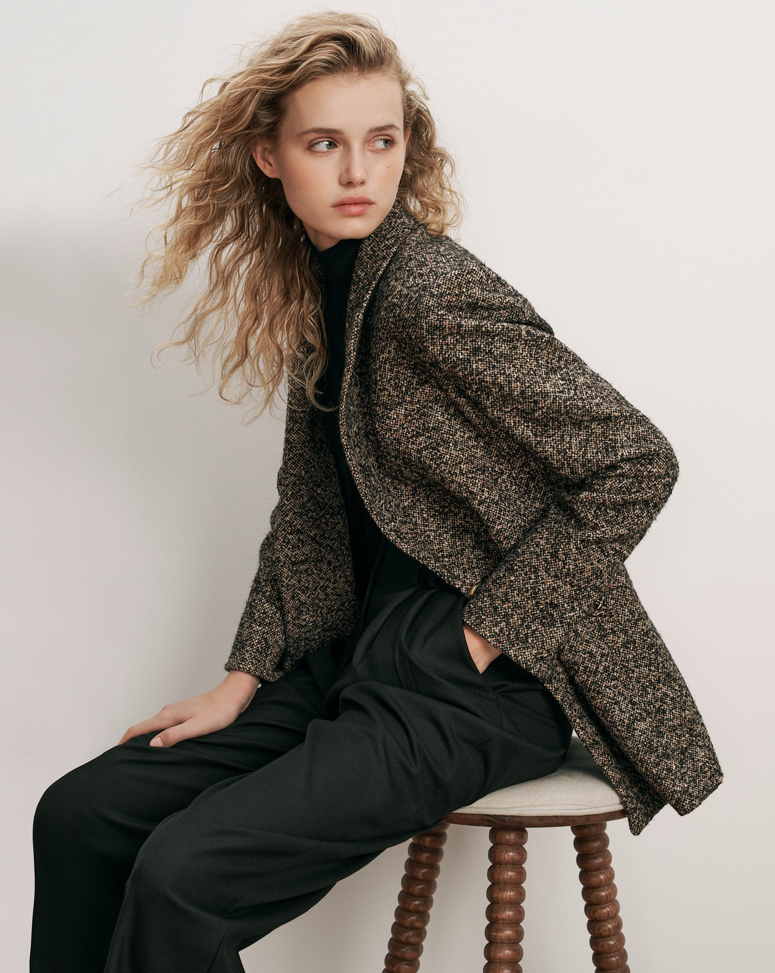 Veronica Beard Brown tweed blazer, black turtleneck, and black trousers.