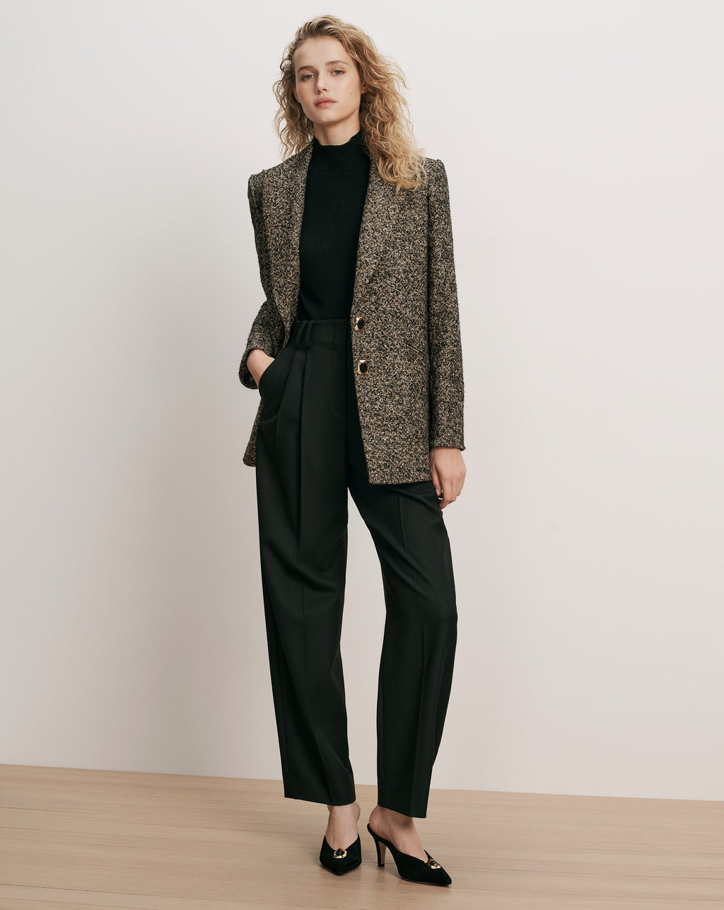 Veronica Beard Black and brown tweed blazer, black turtleneck, and black trousers.
