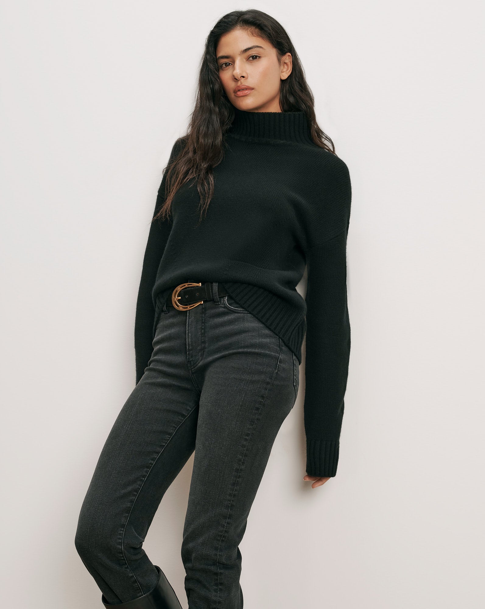 Veronica Beard Black turtleneck sweater, dark gray jeans, black belt.