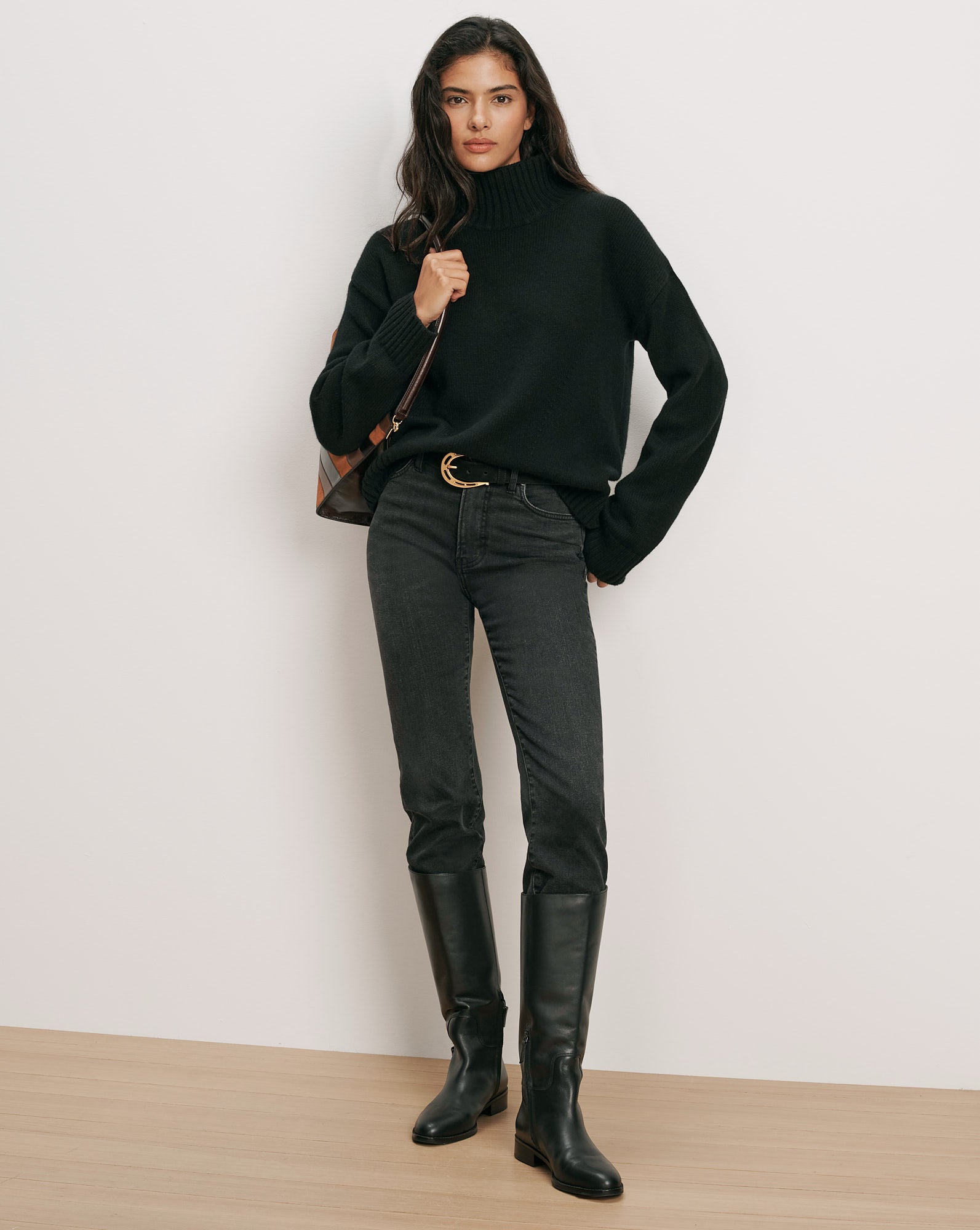 Veronica Beard Black turtleneck sweater, dark wash jeans, black boots.