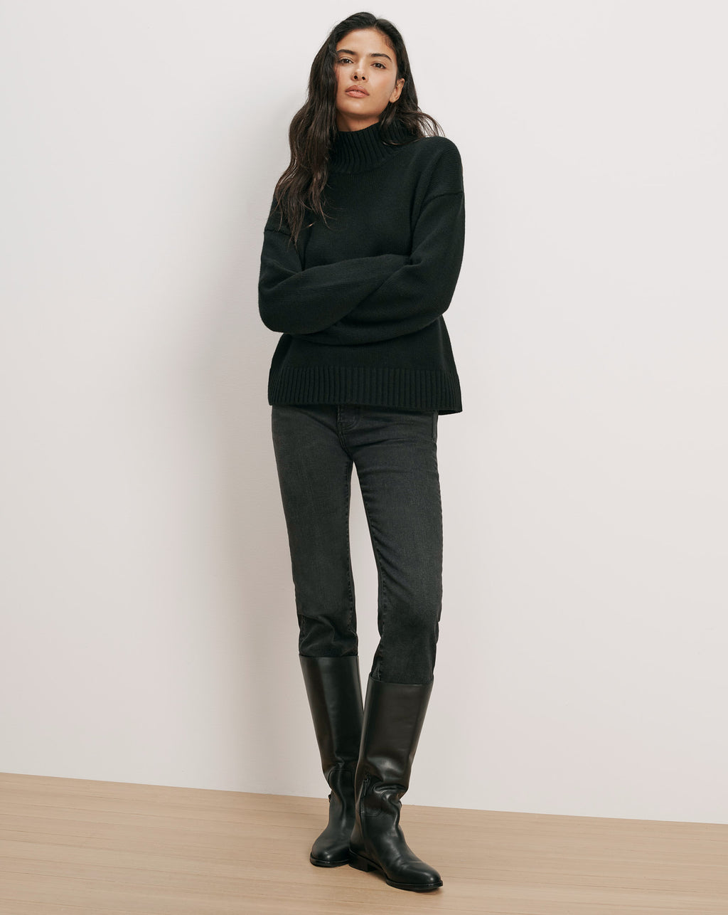 Veronica Beard Black turtleneck sweater, black jeans, black boots.
