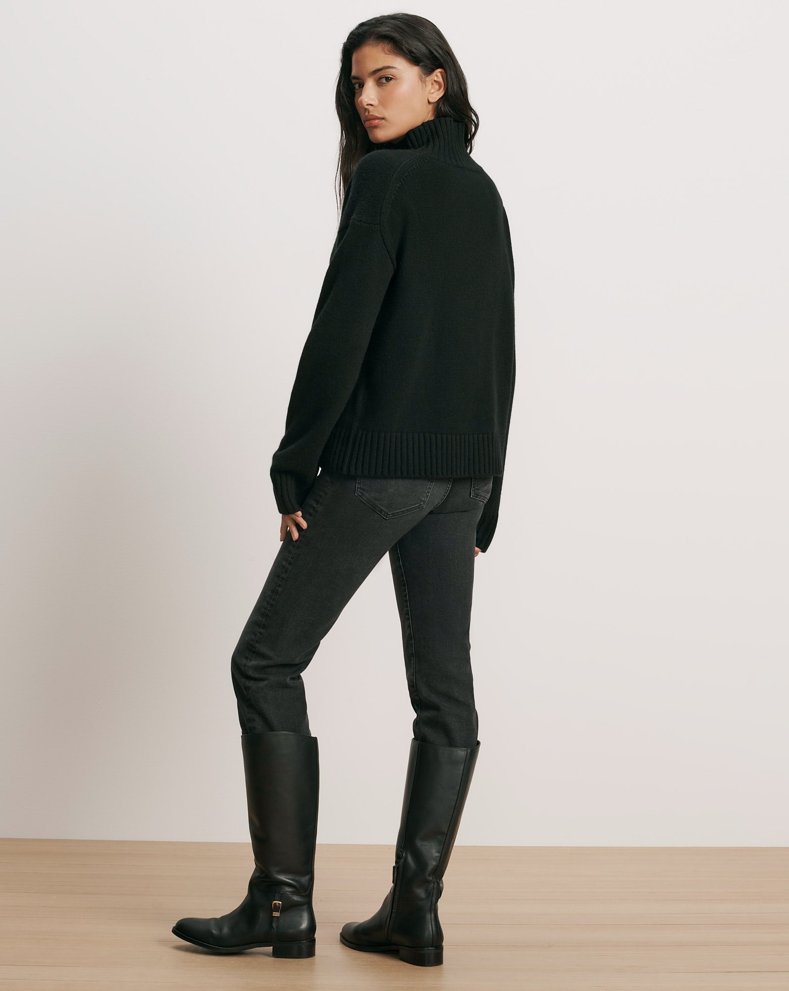 Veronica Beard Black turtleneck sweater, dark wash jeans, black leather boots.