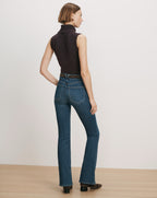 Veronica Beard Dark wash flare jeans with a brown sleeveless turtleneck.