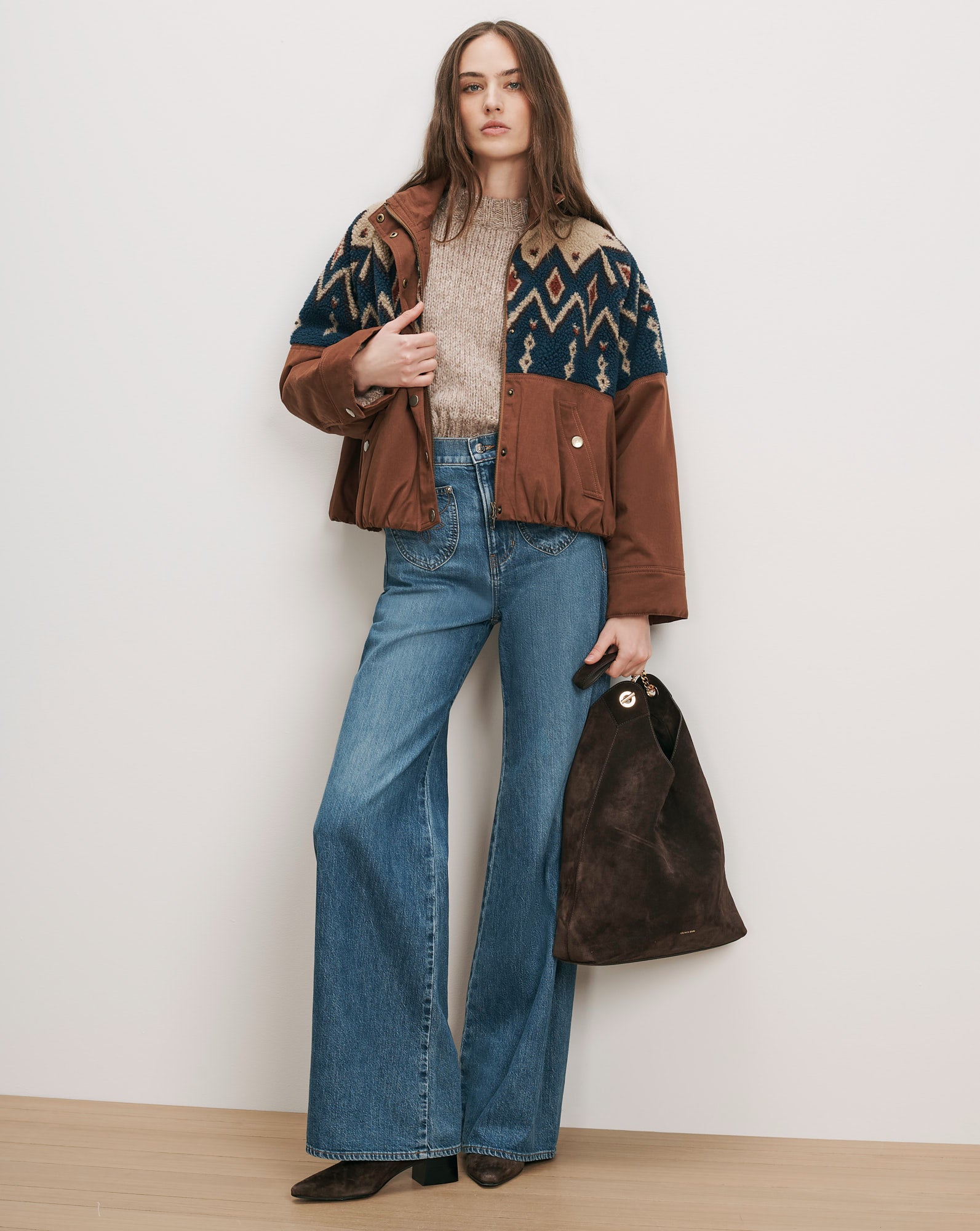 Veronica Beard Brown jacket with patterned yoke, beige sweater, blue jeans, brown bag.