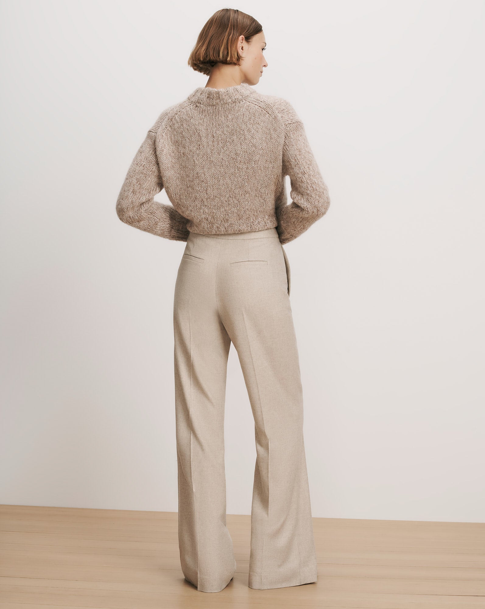 Veronica Beard Beige knit sweater and light beige wide-leg trousers.