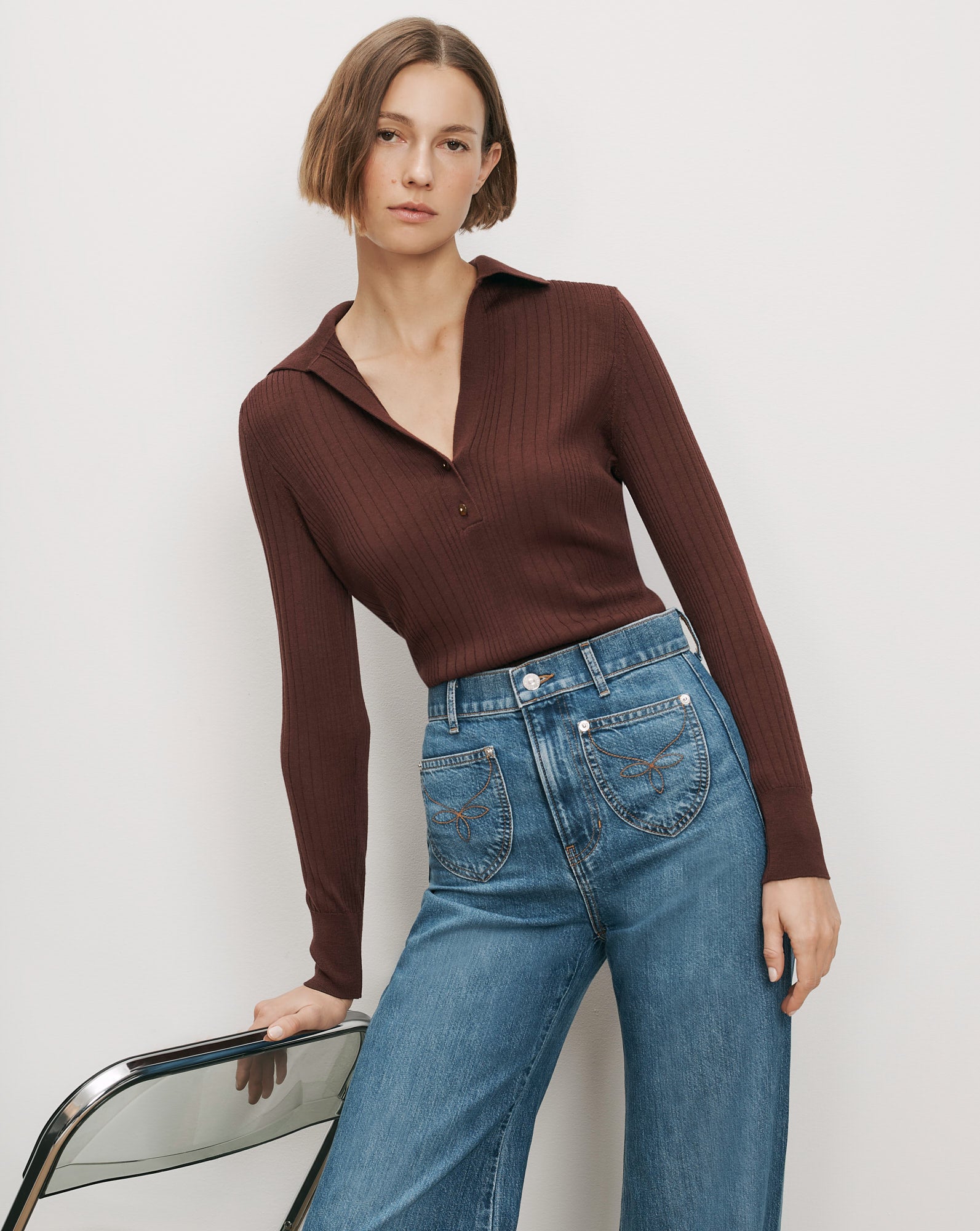 Veronica Beard Brown ribbed knit polo shirt and blue wide-leg jeans.
