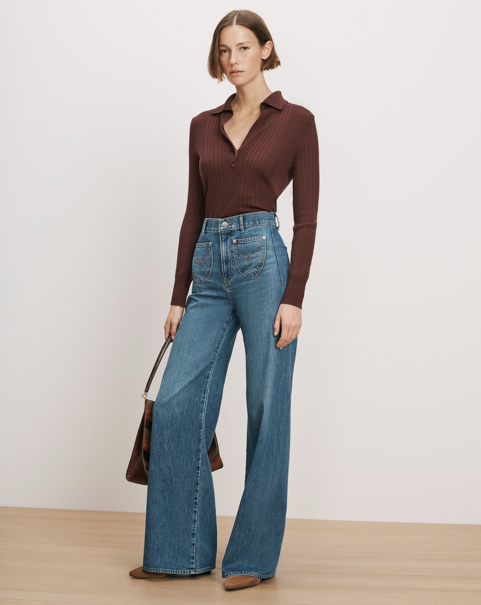 Veronica Beard Brown ribbed knit polo, blue wide-leg jeans.