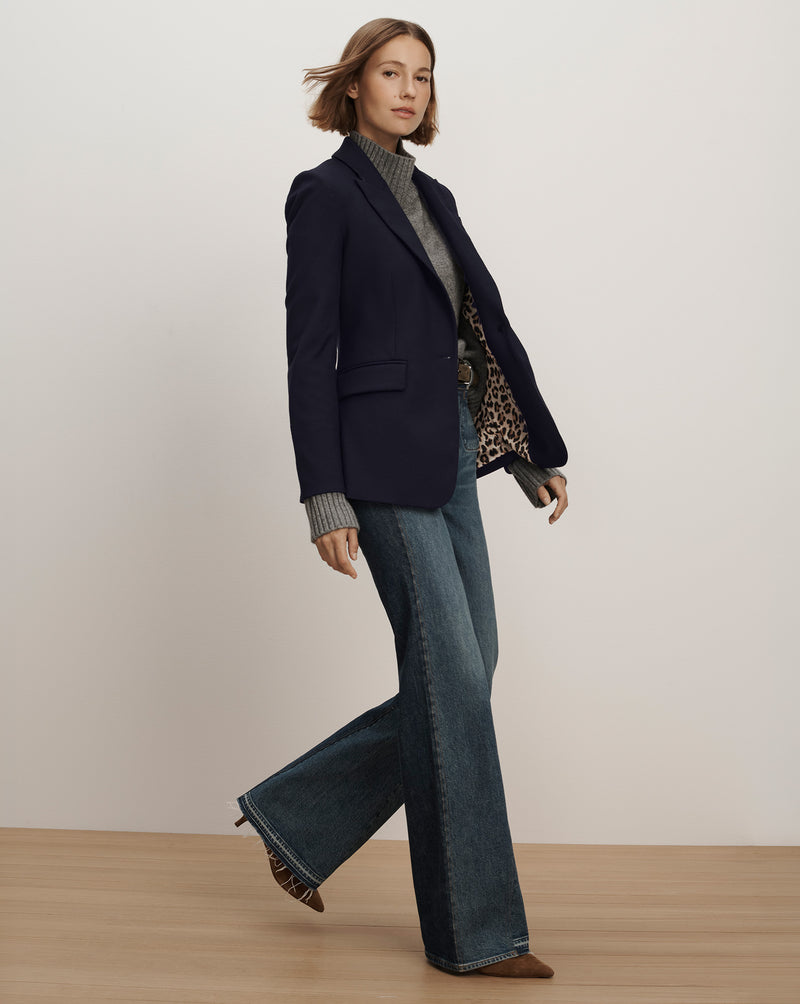 Veronica Beard Navy blazer, black top, blue flare jeans.