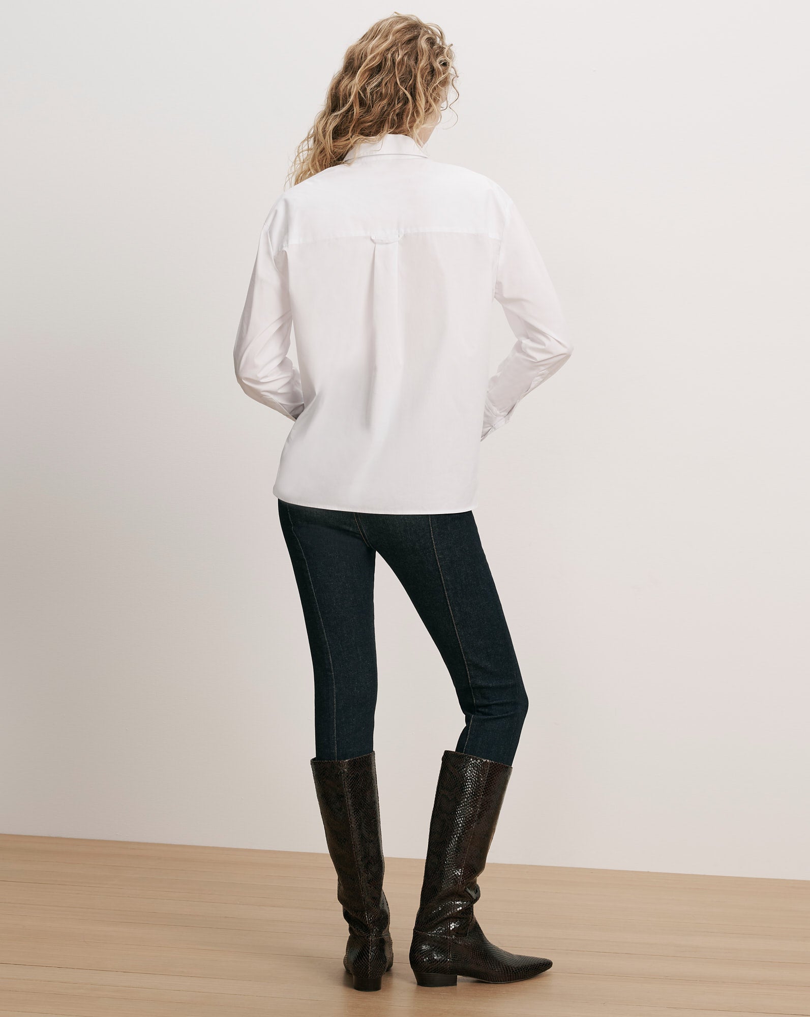 Veronica Beard White cotton button-up shirt, dark wash jeans, brown boots.