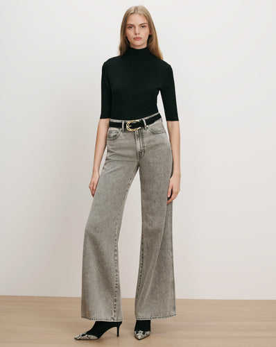 Veronica Beard Black ribbed turtleneck, gray wide-leg jeans, black belt.