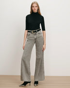 Veronica Beard Black ribbed turtleneck, gray wide-leg jeans, black belt.
