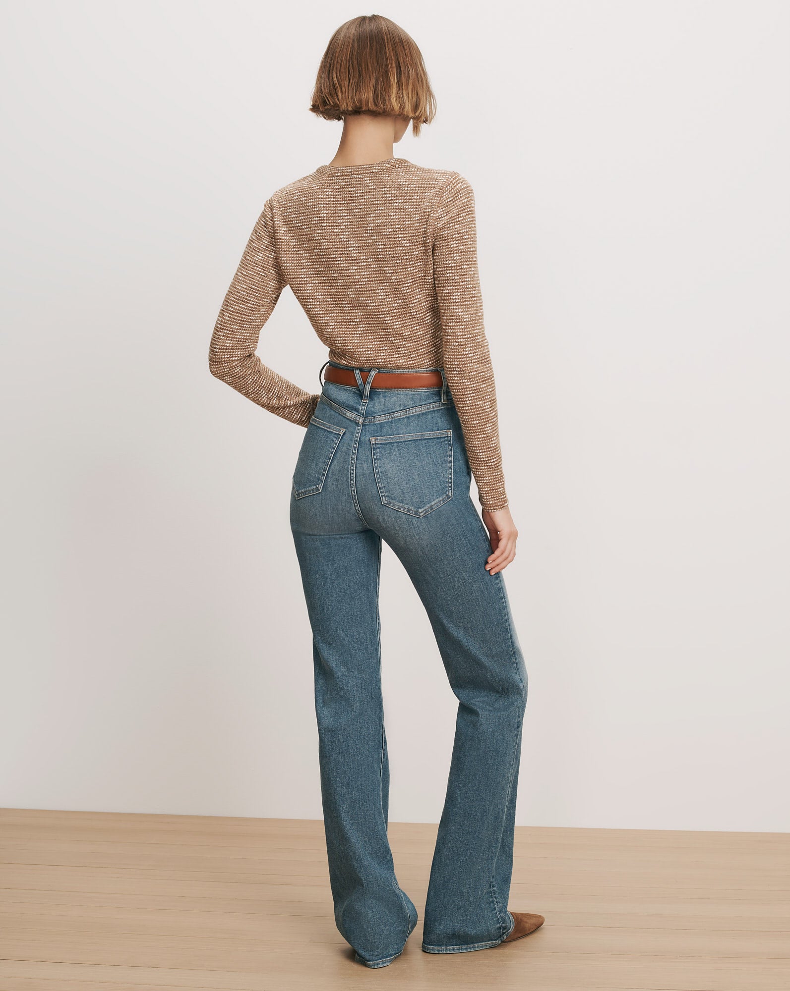 Veronica Beard Brown striped knit top, blue flared jeans, brown belt.