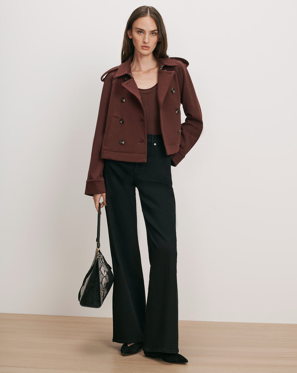 Veronica Beard Brown peacoat, black wide-leg pants, and snakeskin handbag.