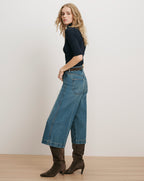 Veronica Beard Navy ribbed turtleneck, wide-leg jeans, brown suede boots.