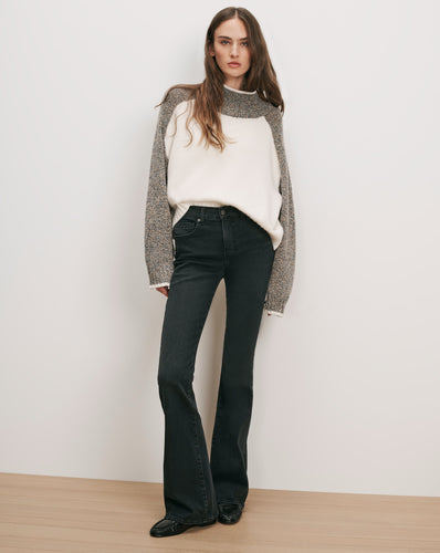 Veronica Beard Color-block raglan sweater and dark wash flare jeans.