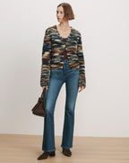 Veronica Beard Striped fuzzy cardigan, brown top, flared jeans, brown boots, handbag.
