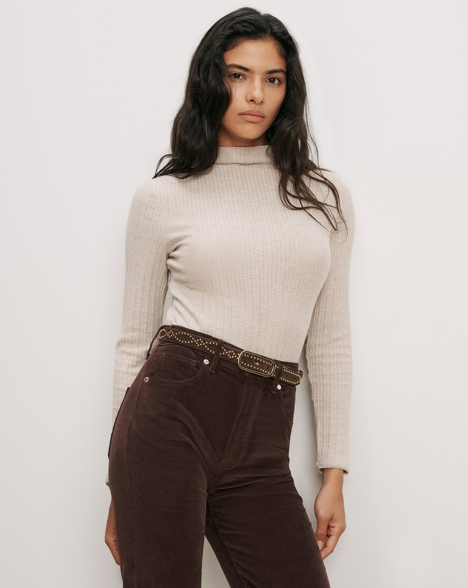 Veronica Beard Beige ribbed turtleneck, brown corduroy pants, studded belt.