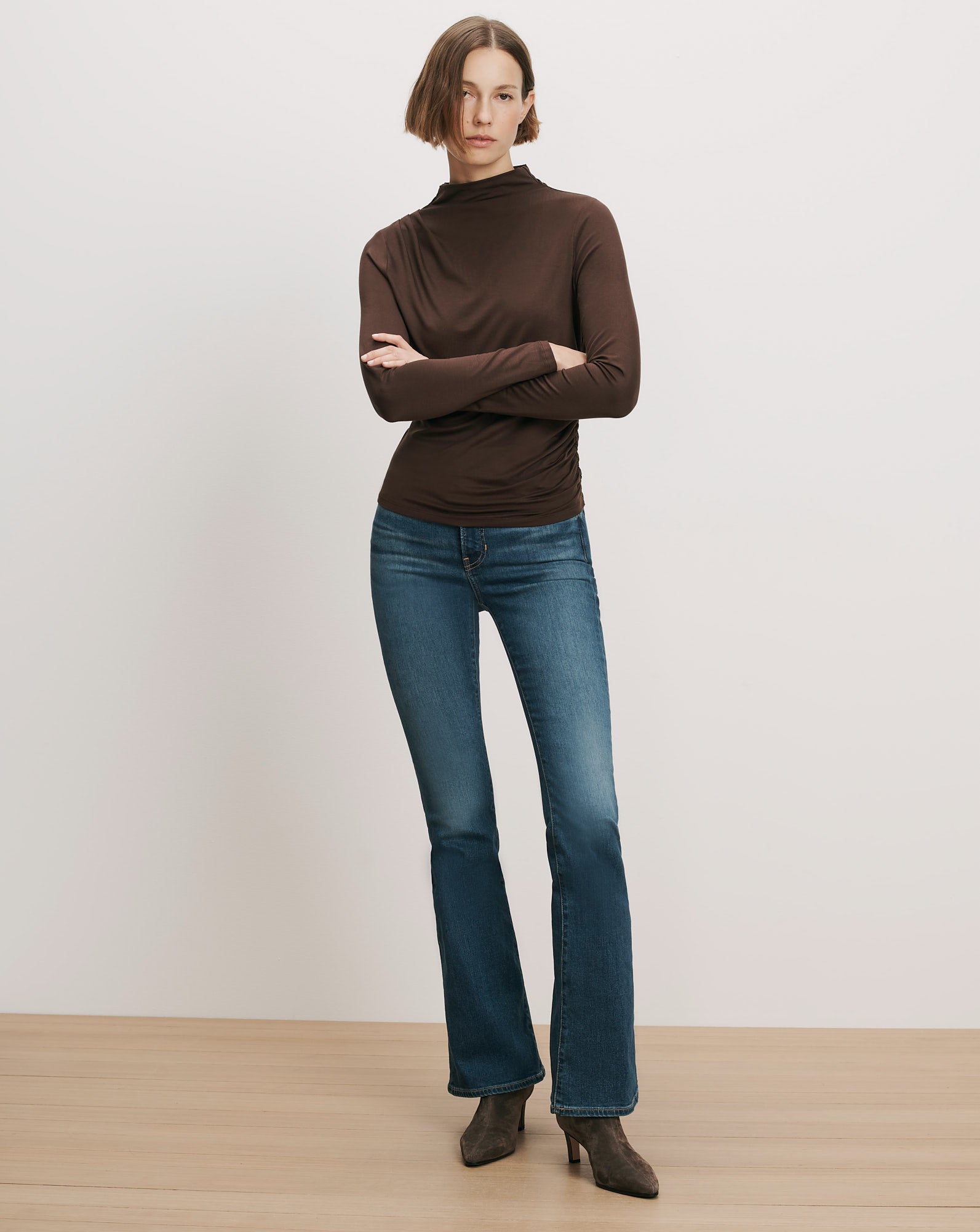 Veronica Beard Brown long-sleeve turtleneck top and blue flare jeans.