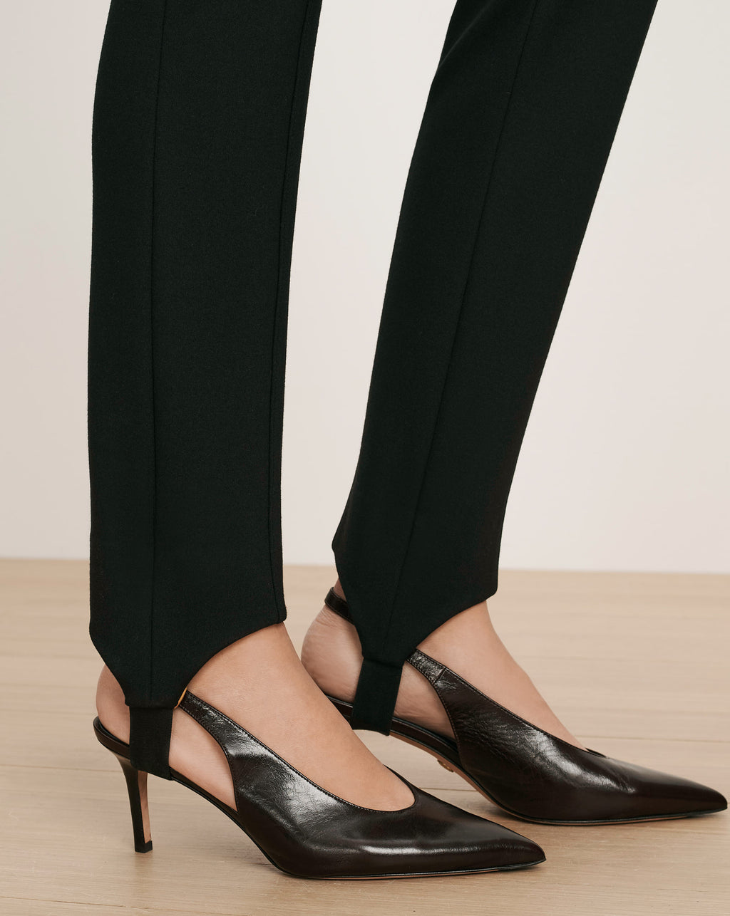 Veronica Beard Black stirrup pants with black slingback heels.