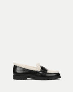 Veronica Beard Black patent leather shearling-lined lug sole loafer.