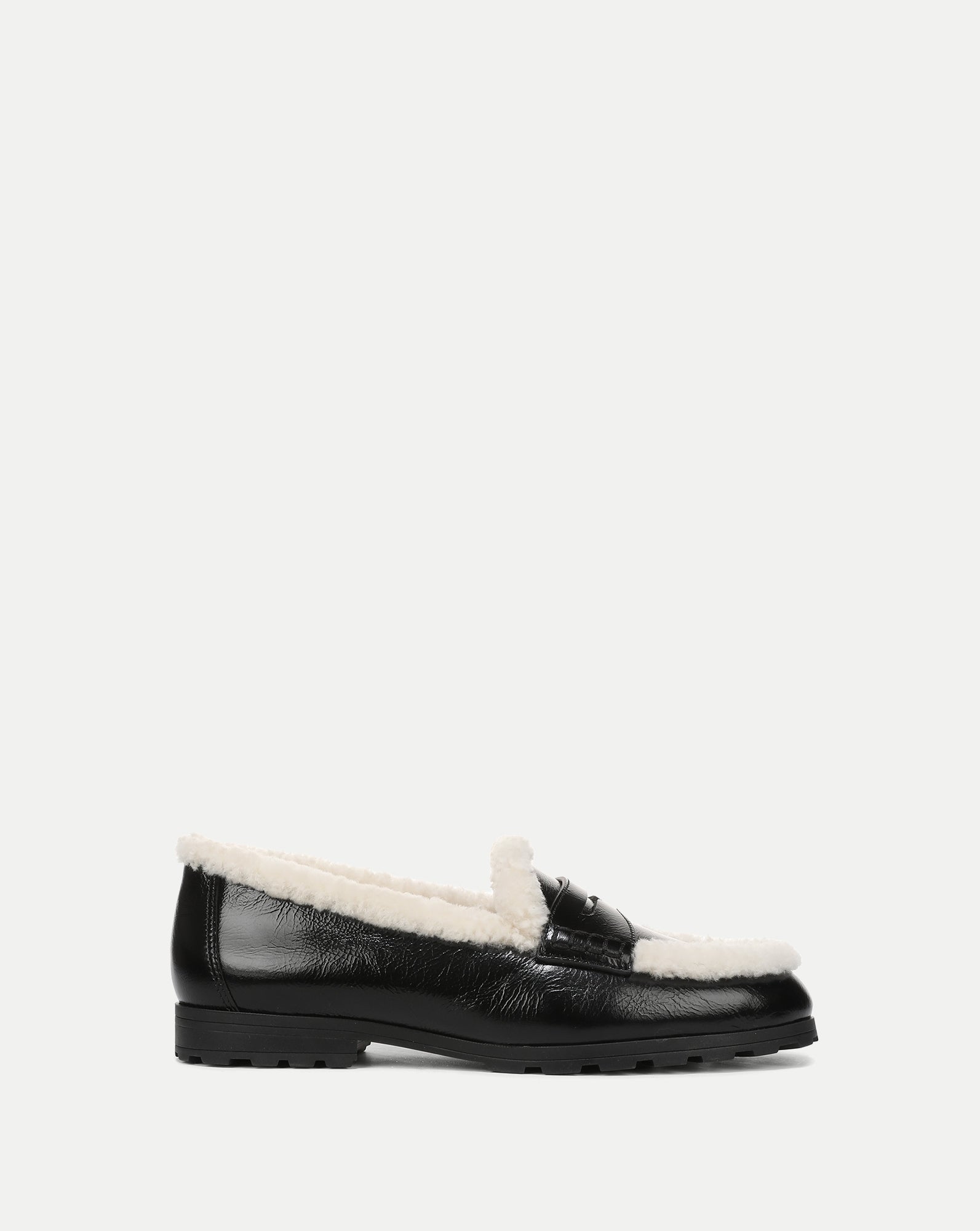 Veronica Beard Black patent leather shearling-lined lug sole loafer.