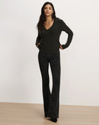 Veronica Beard Dark green V-neck sweater and black flared jeans.