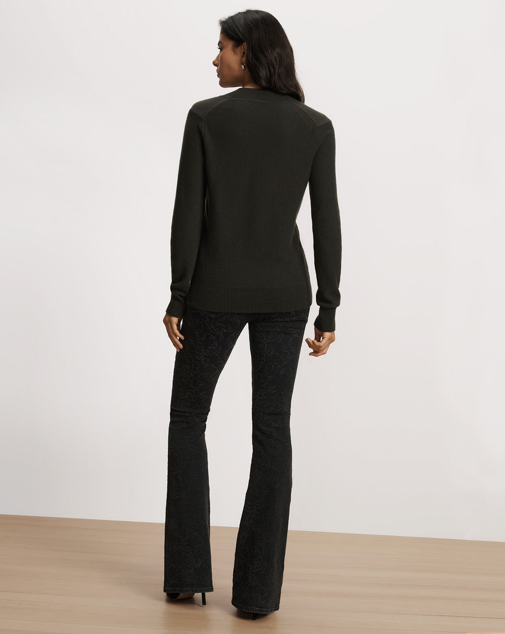 Veronica Beard Dark green long-sleeve sweater and patterned black pants.
