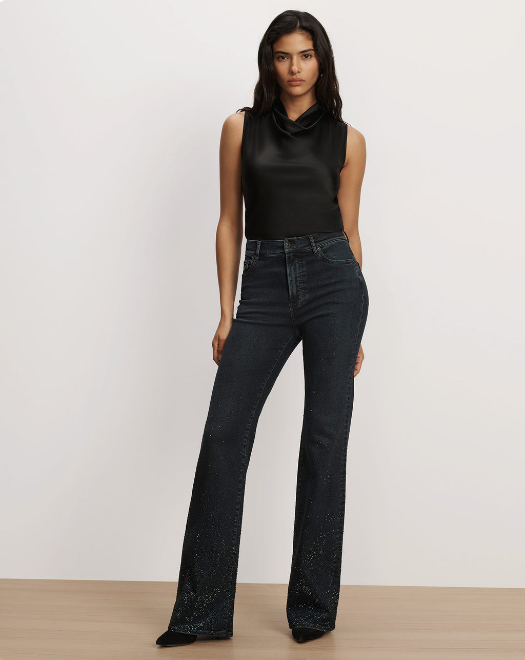 Veronica Beard Black satin sleeveless cowl-neck top and dark embellished jeans.