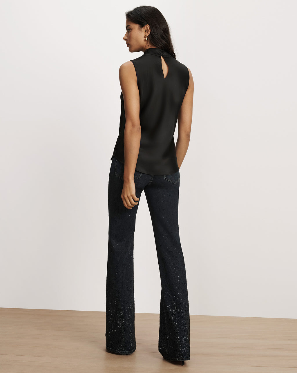 Veronica Beard Black sleeveless satin top and embellished flare jeans.
