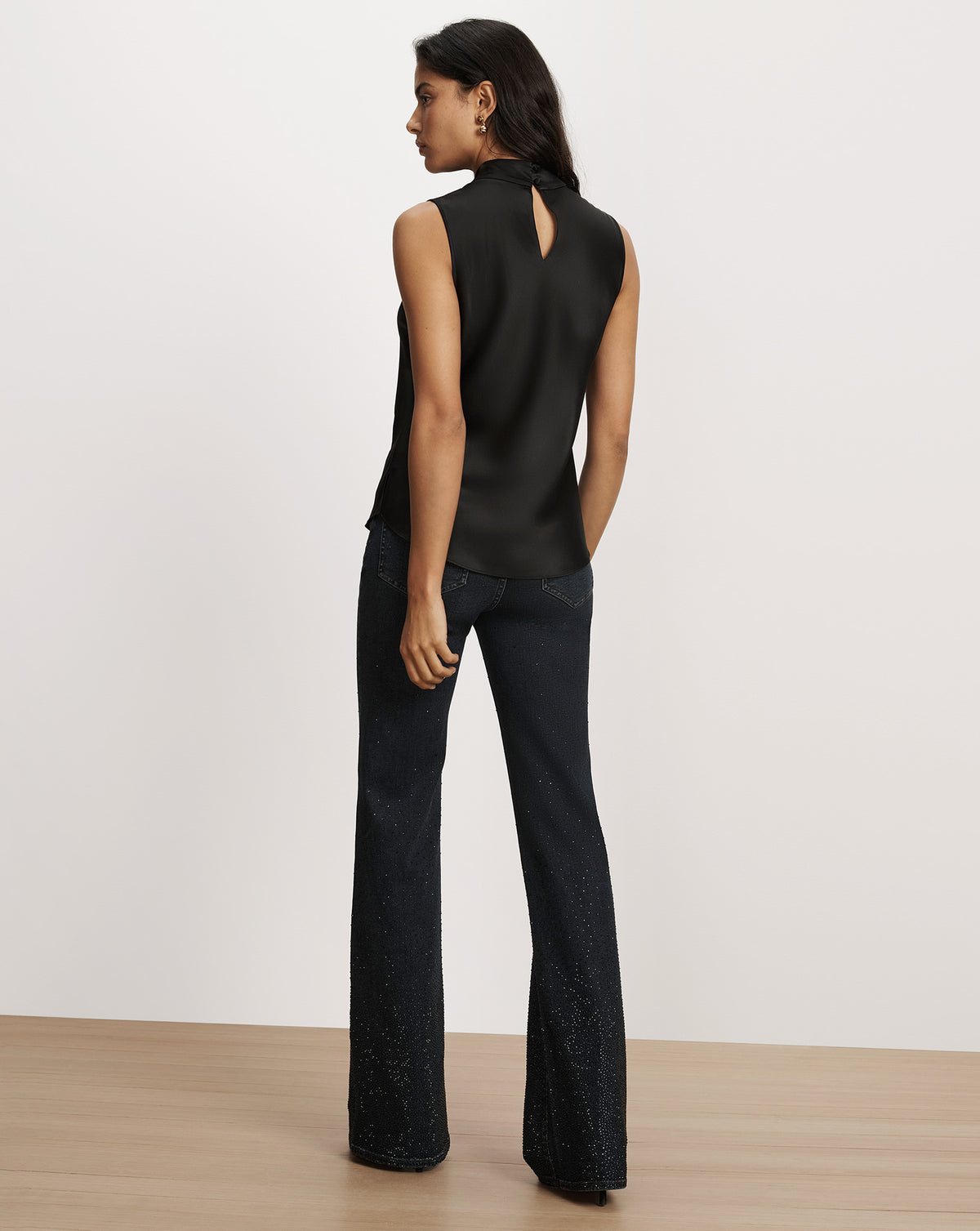 Veronica Beard Black sleeveless satin top and embellished flare jeans.