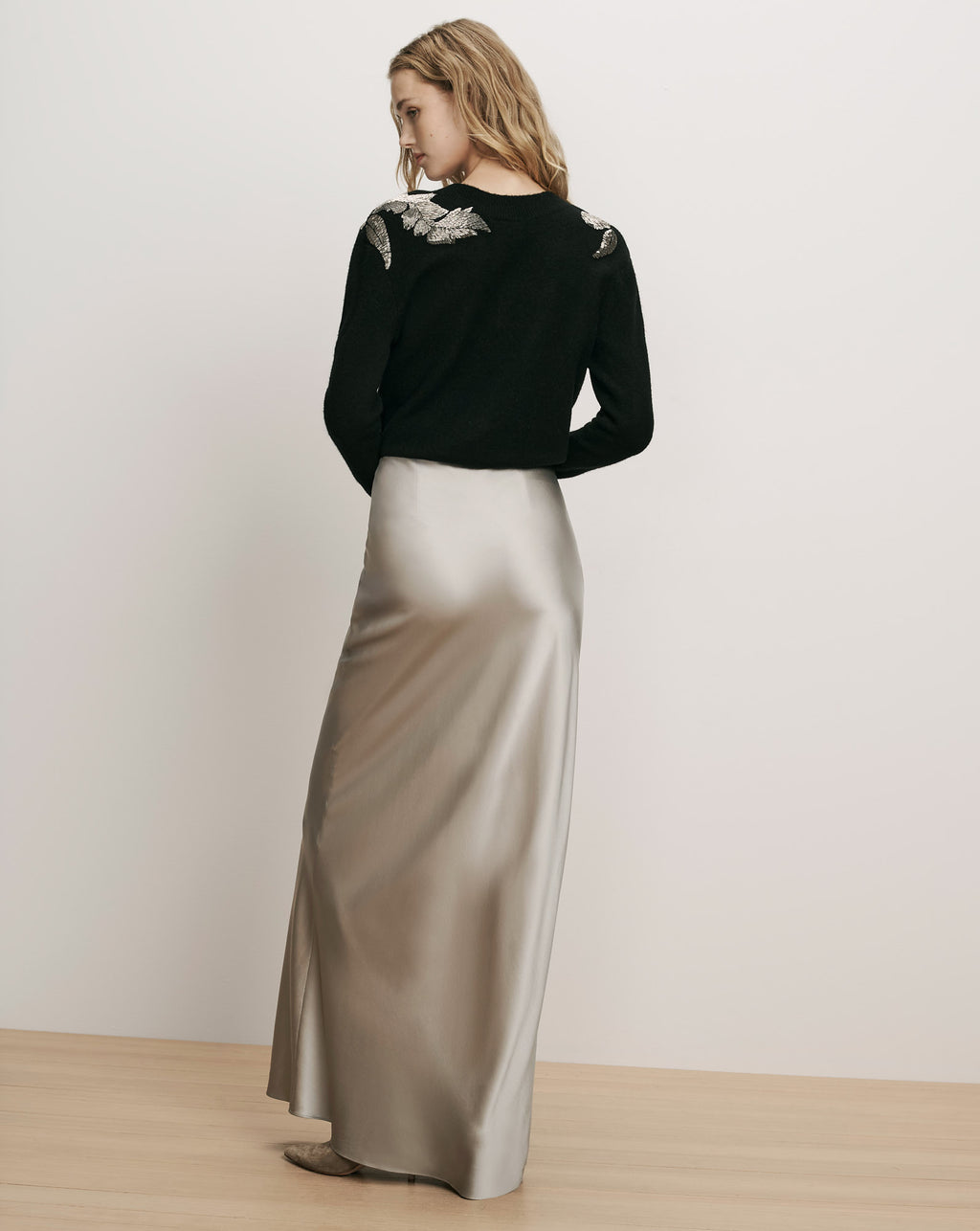 Veronica Beard Black sweater and metallic silver silk maxi skirt.