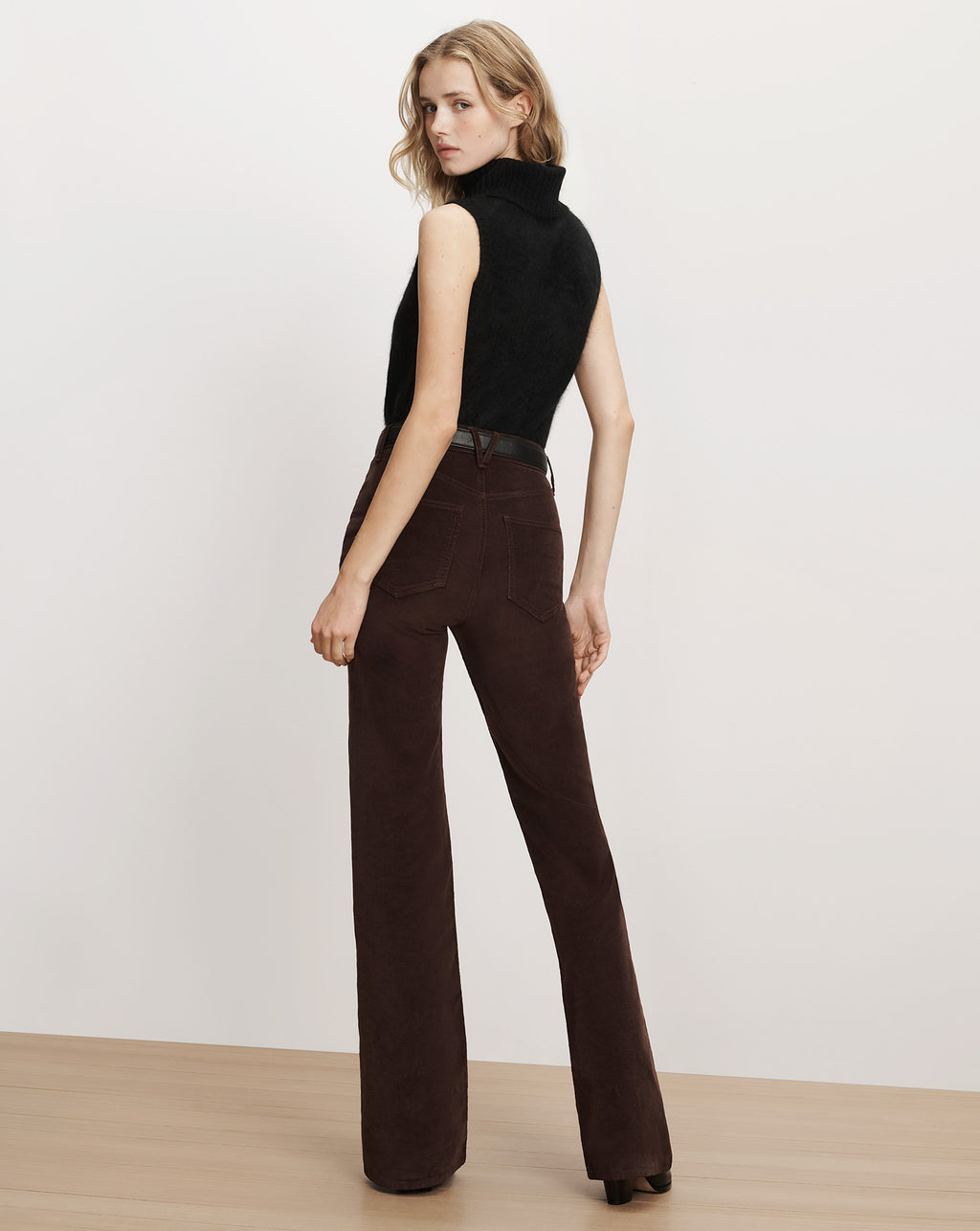 Veronica Beard Black sleeveless turtleneck sweater and brown corduroy trousers.