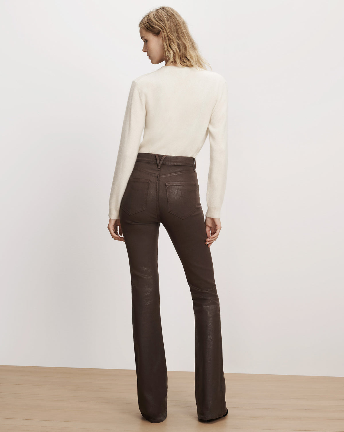 Veronica Beard Brown coated flared pants with white sweater.