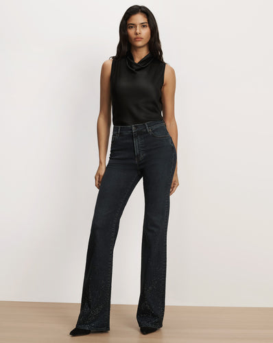 Veronica Beard Black sleeveless satin top and dark denim jeans.
