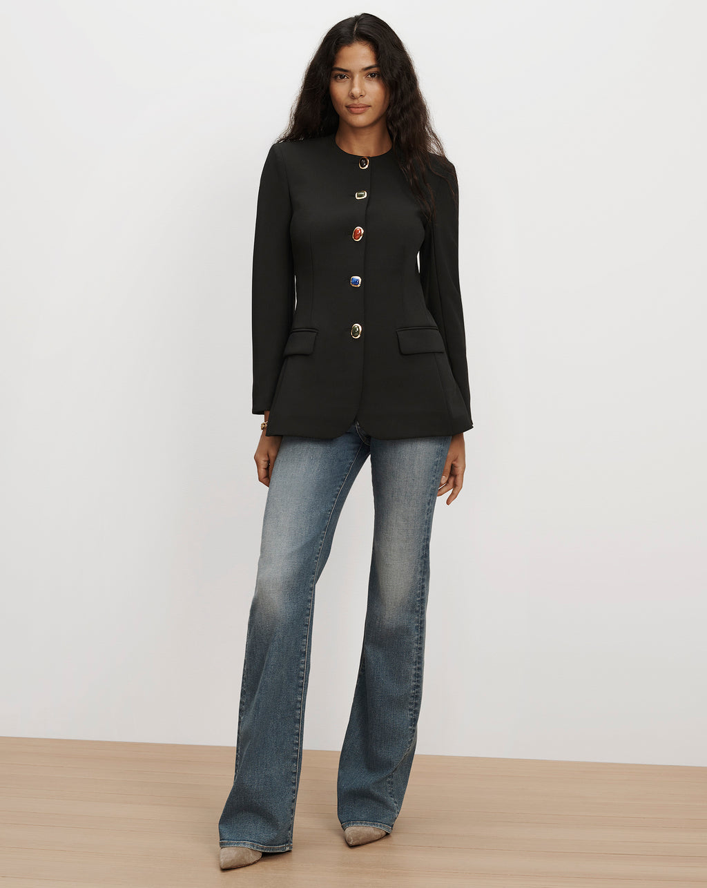 Veronica Beard Black blazer with decorative jewel buttons and flared jeans.