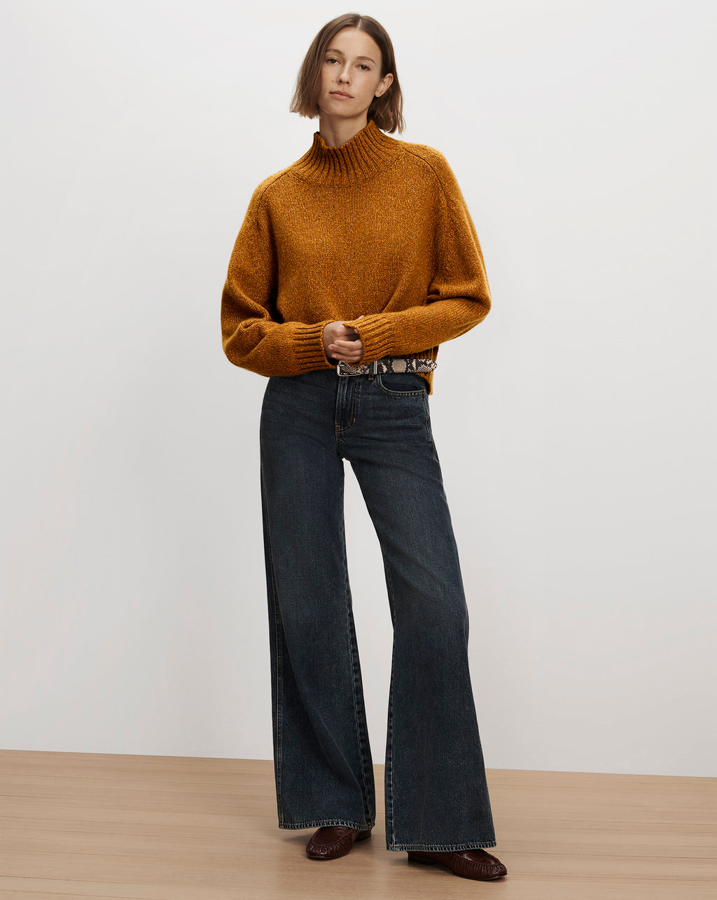 Veronica Beard Mustard turtleneck sweater and dark wide jeans.