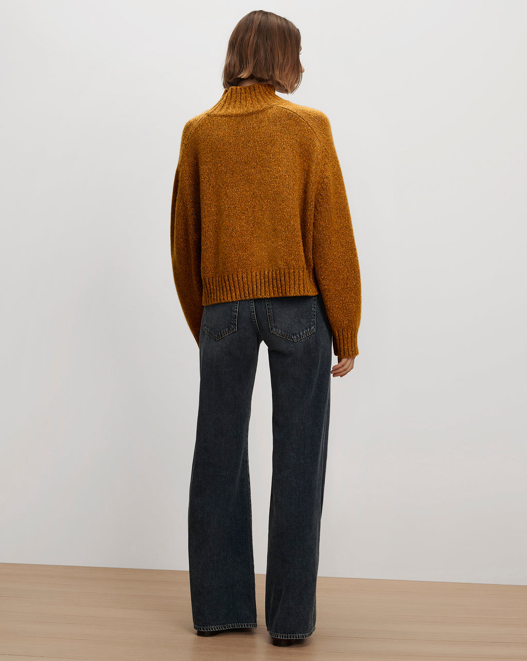 Veronica Beard Mustard yellow knit sweater and black jeans.
