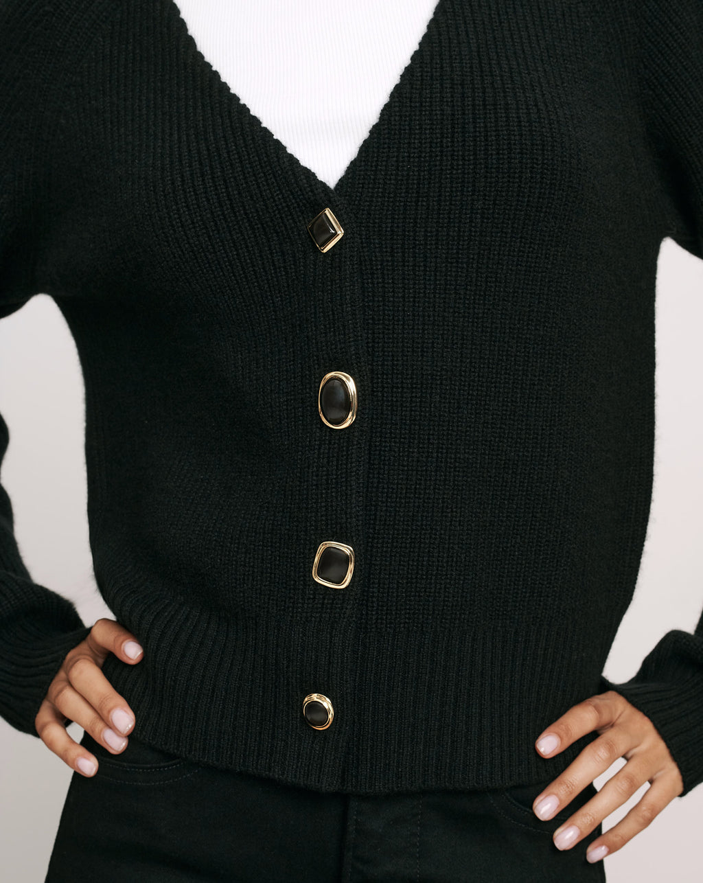 Veronica Beard Black knit cardigan with ornate gold-rimmed buttons.