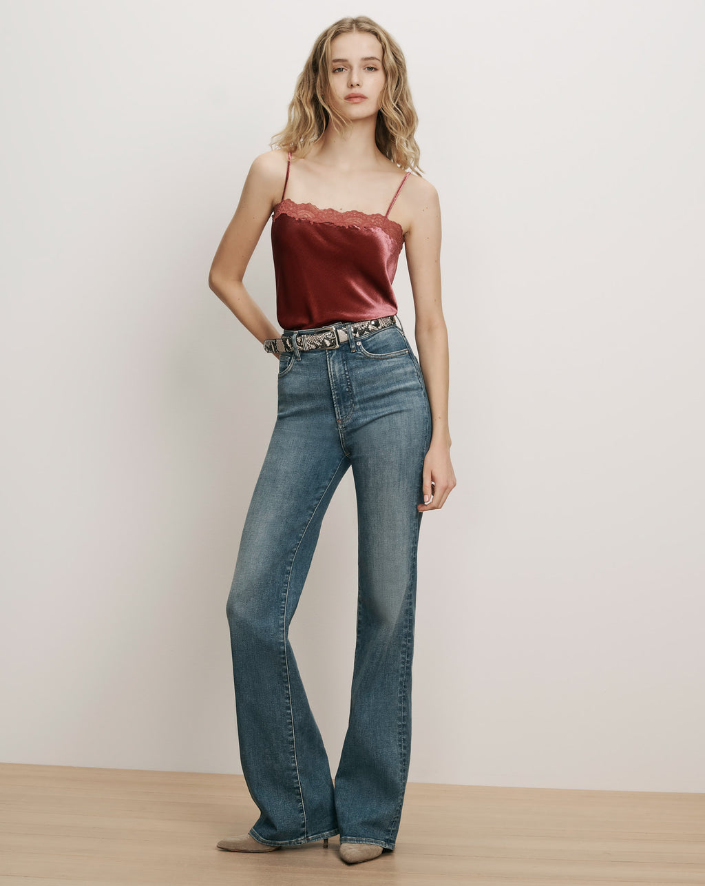 Veronica Beard Burgundy velvet camisole and blue flared denim jeans.