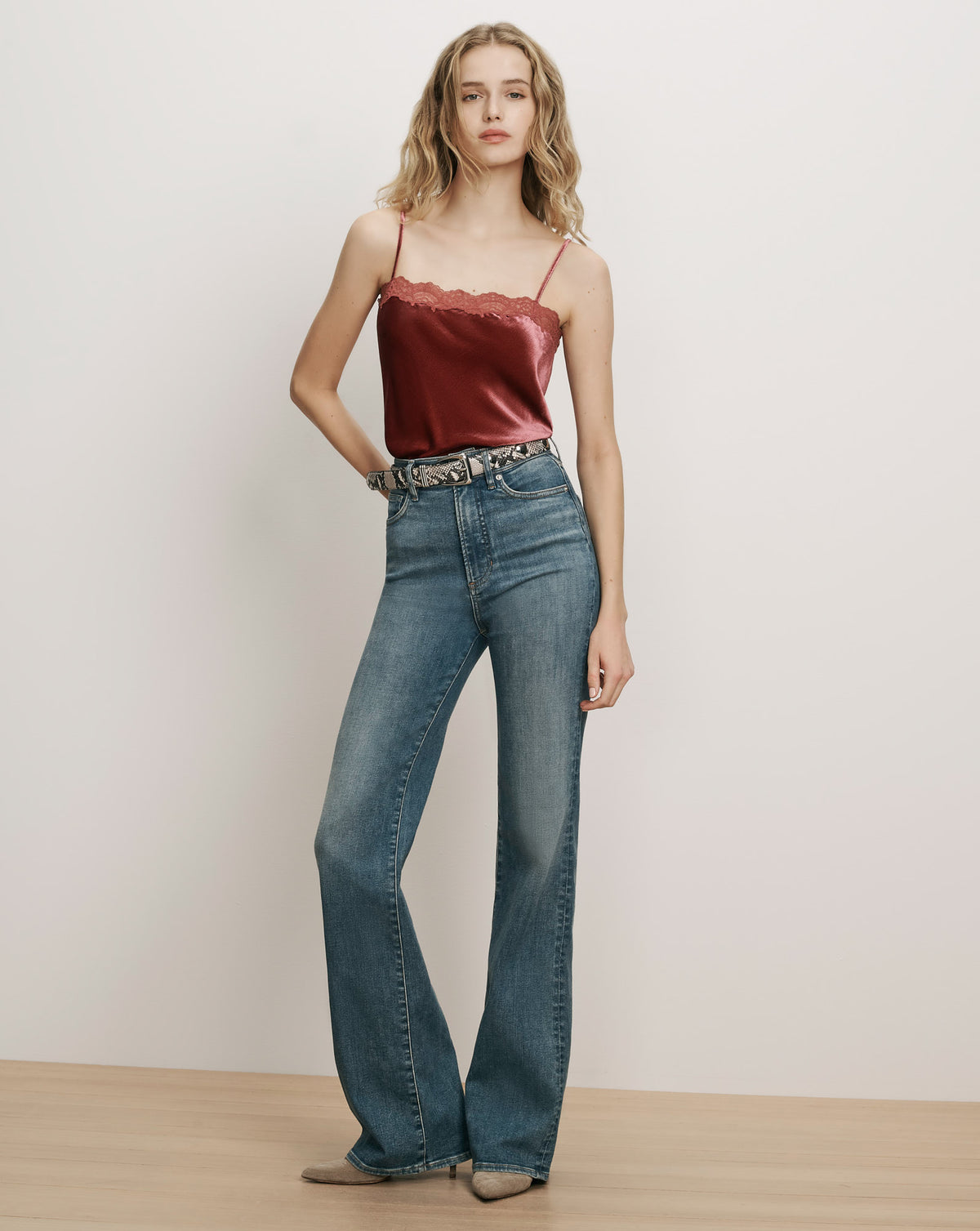 Veronica Beard Burgundy velvet camisole and blue flared denim jeans.