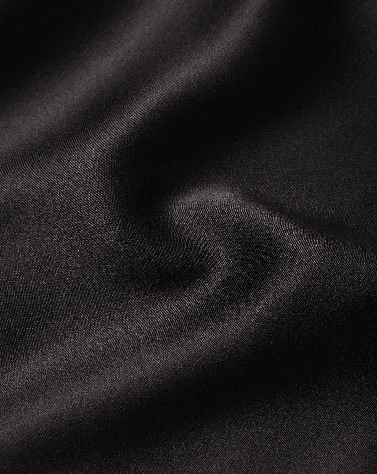 Veronica Beard Black satin fabric with smooth, wavy texture.