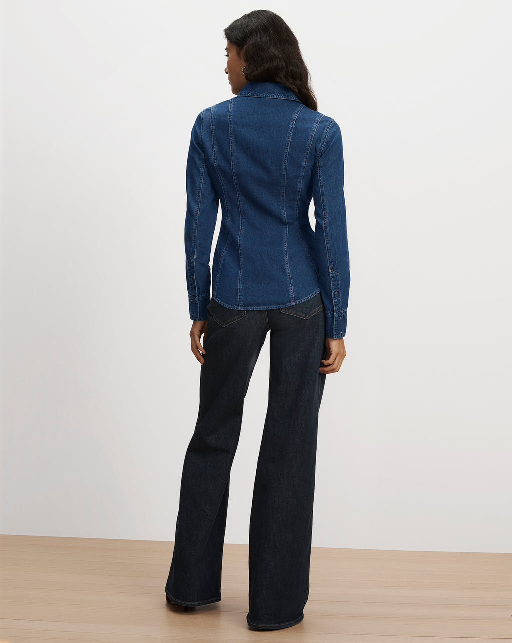 Veronica Beard Blue denim shirt and black flared jeans.