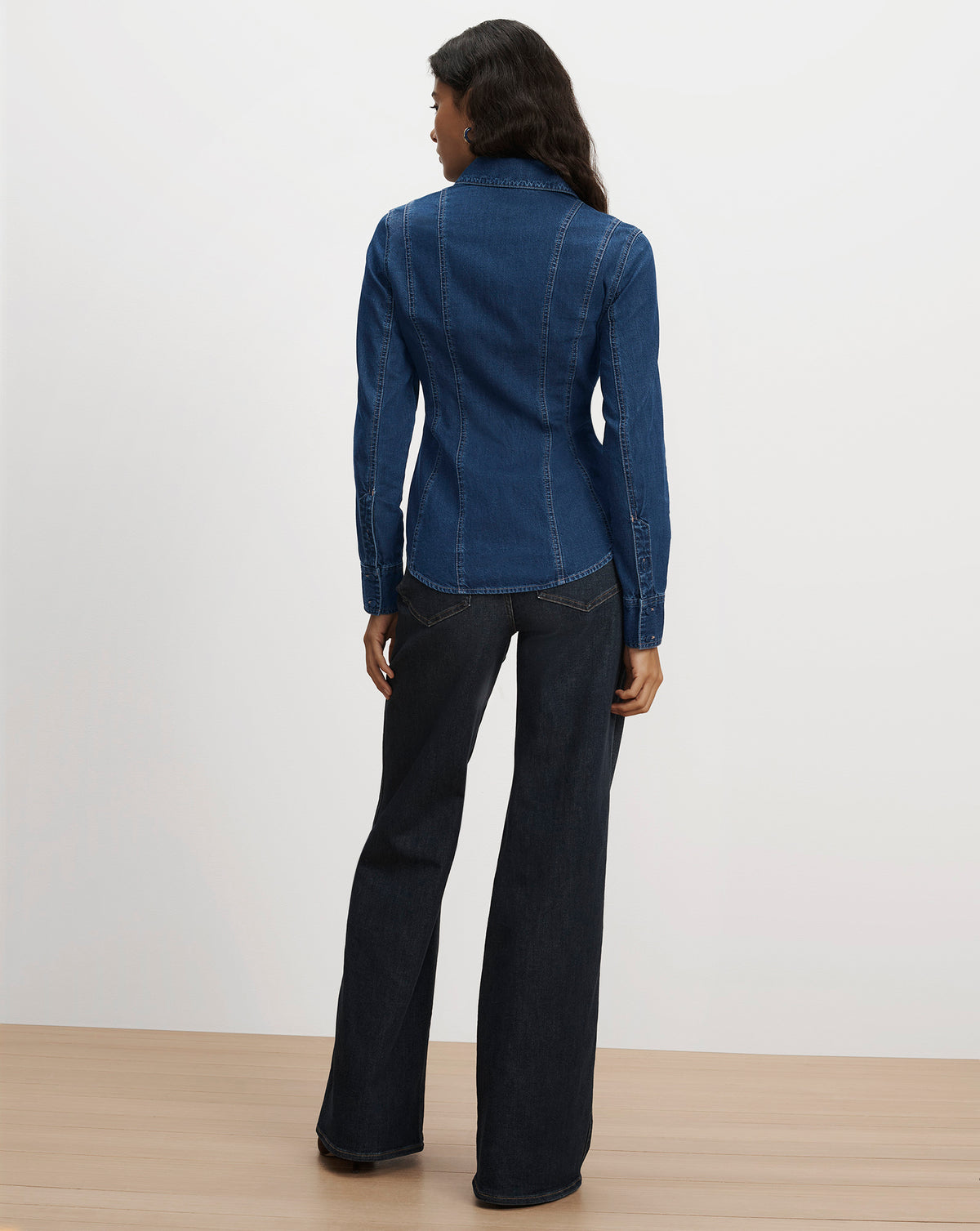 Veronica Beard Blue denim shirt and black flared jeans.