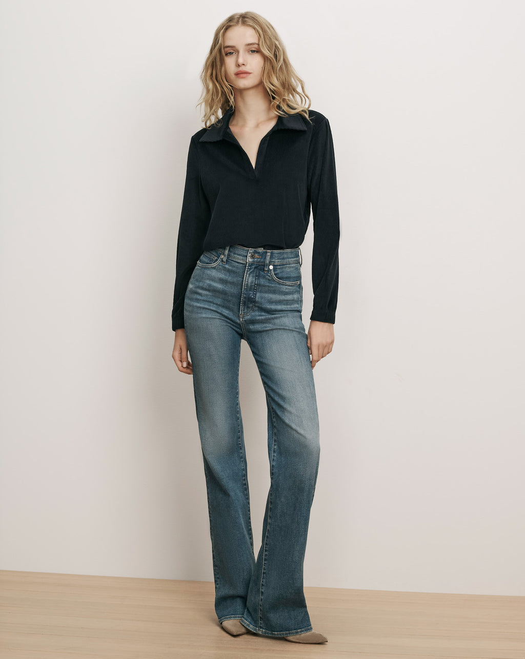 Veronica Beard Black ribbed collared shirt and blue denim jeans.