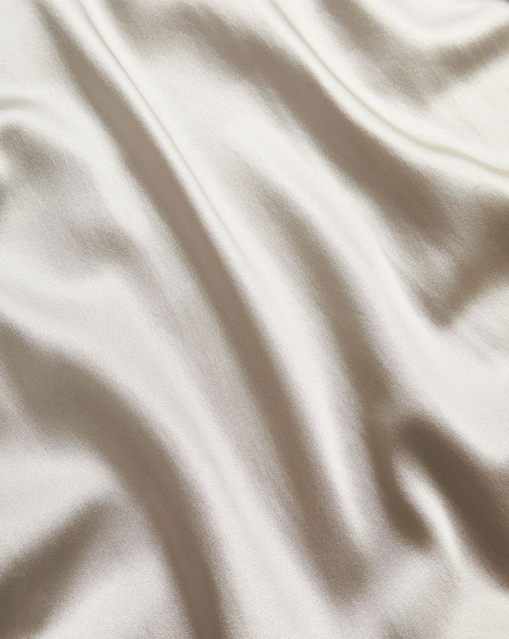 Veronica Beard Glossy silver satin fabric with soft folds.