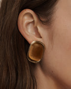 Veronica Beard Gold-framed rectangular earrings with a smooth, amber-colored stone.