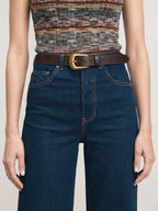 Veronica Beard Dark blue jeans, brown leather belt, multicolored knit top.