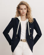 Veronica Beard Navy double-breasted blazer with white hoodie and white pants.