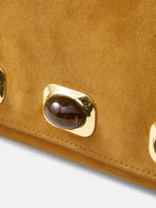 Veronica Beard Tan suede handbag with gold-rimmed brown gemstone embellishment.