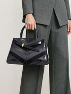 Veronica Beard Black leather handbag, chevron pattern, structured trapezoid silhouette.